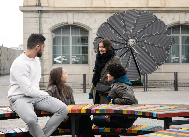 Quatre personnes discutent en extérieur